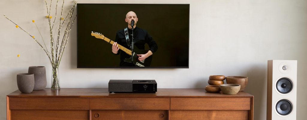 Naim Uniti Nova auf einem Regal neben Focal Standlautsprechern
