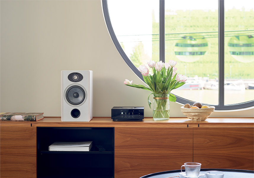 Naim Uniti Atom auf einem Regal neben einem Focal Kompaktlautsprecher